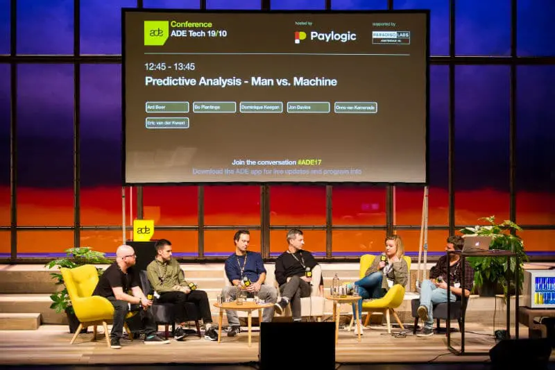Multiple speakers sit on a stage at the Amsterdam dance event